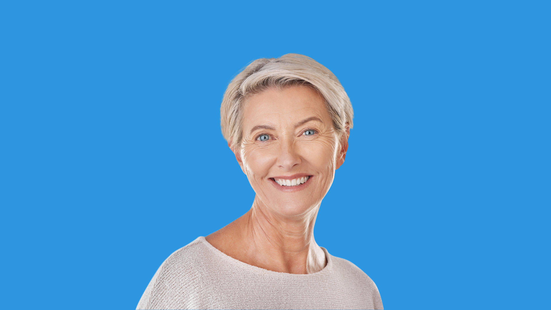 A senior woman with short hair smiling for a picture.